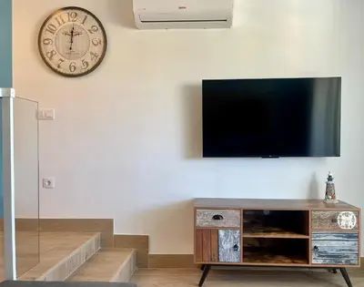 Una televisión o centro de entretenimiento en PARAISO designer conditioned apartment with terrace