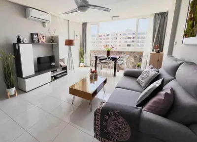 Una televisión o centro de entretenimiento en Apartamento con piscina y aire acondicionado