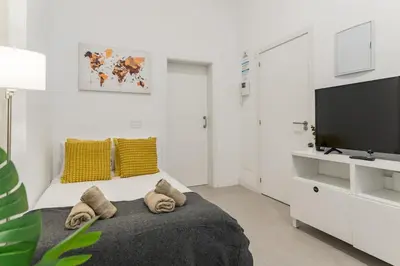 Una televisión o centro de entretenimiento en Beachside Groundfloor Apartment Las Canteras Shared Rooftop