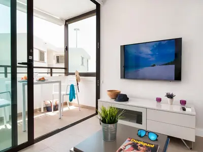 Una televisión o centro de entretenimiento en Beachfront Apartment Siesta 21 San Agustin Playa by VillaGranCanaria