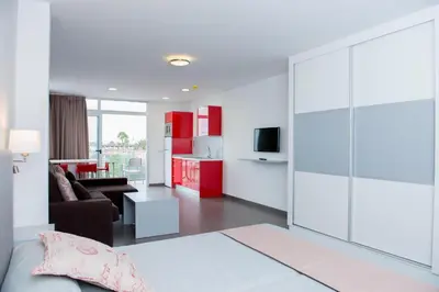 Una televisión o centro de entretenimiento en Apartamentos El Palmar