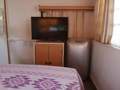 Una televisión o centro de entretenimiento en House Camping Pasito Blanco