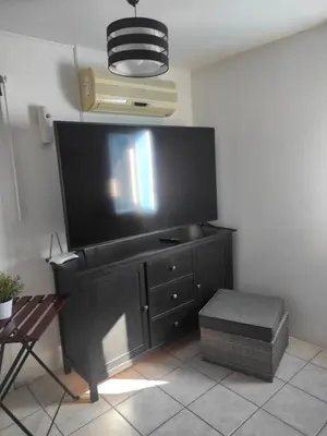 Una televisión o centro de entretenimiento en Ático Arinaga con vistas , jacuzzi , terraza y barbacoa